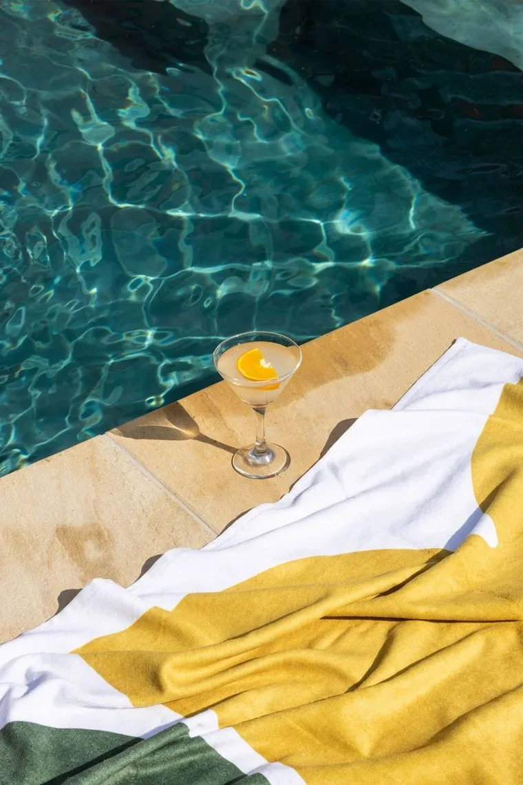 Cocktail and towel beside the pool